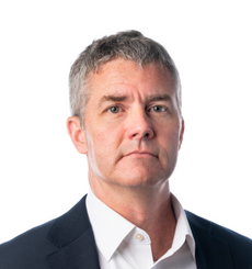 Edmund with a serious expression in a suit and white shirt