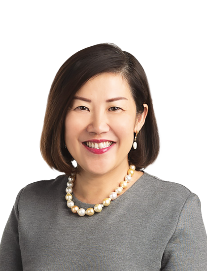 Tan Yen Yen 面带微笑，身穿灰色上衣，佩戴珍珠项链。