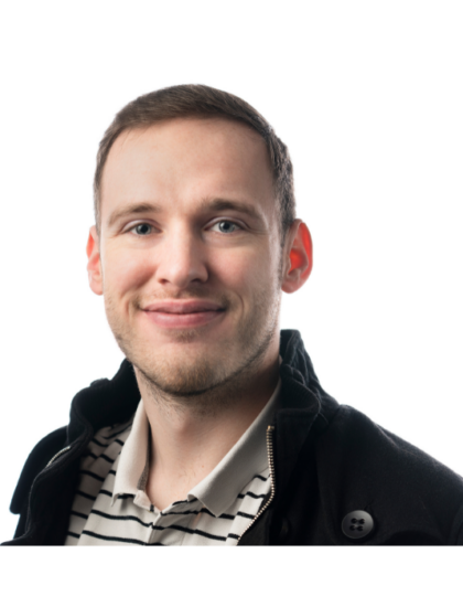 Braden smiling, wearing a black jacket and striped shirt against a white background
