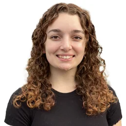 A woman with curly hair smiling.