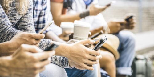 Multicultural friends group using smartphones with coffee