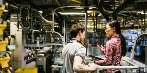 Mechanic And Female Engineer Talking in Factory