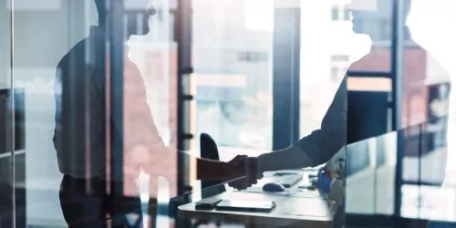 Shot of two businessmen shaking hands in an office